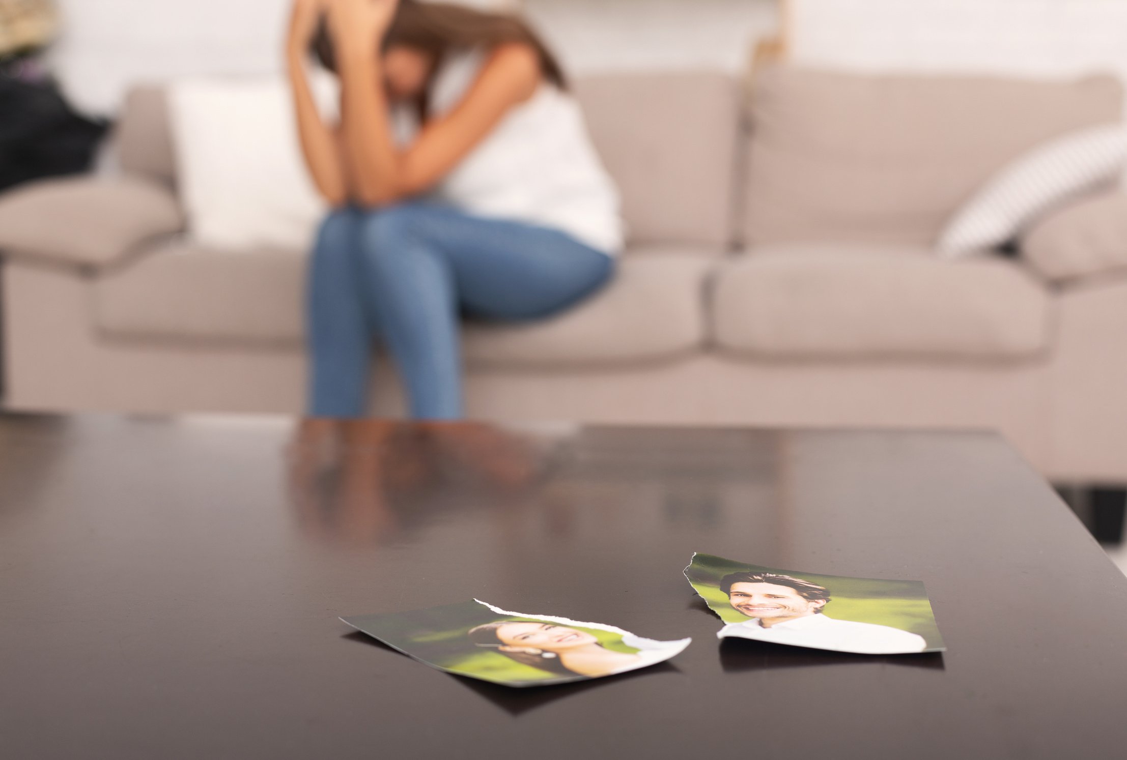 Woman Crying After Breakup With Ex-Boyfriend Sitting On Sofa Indoor